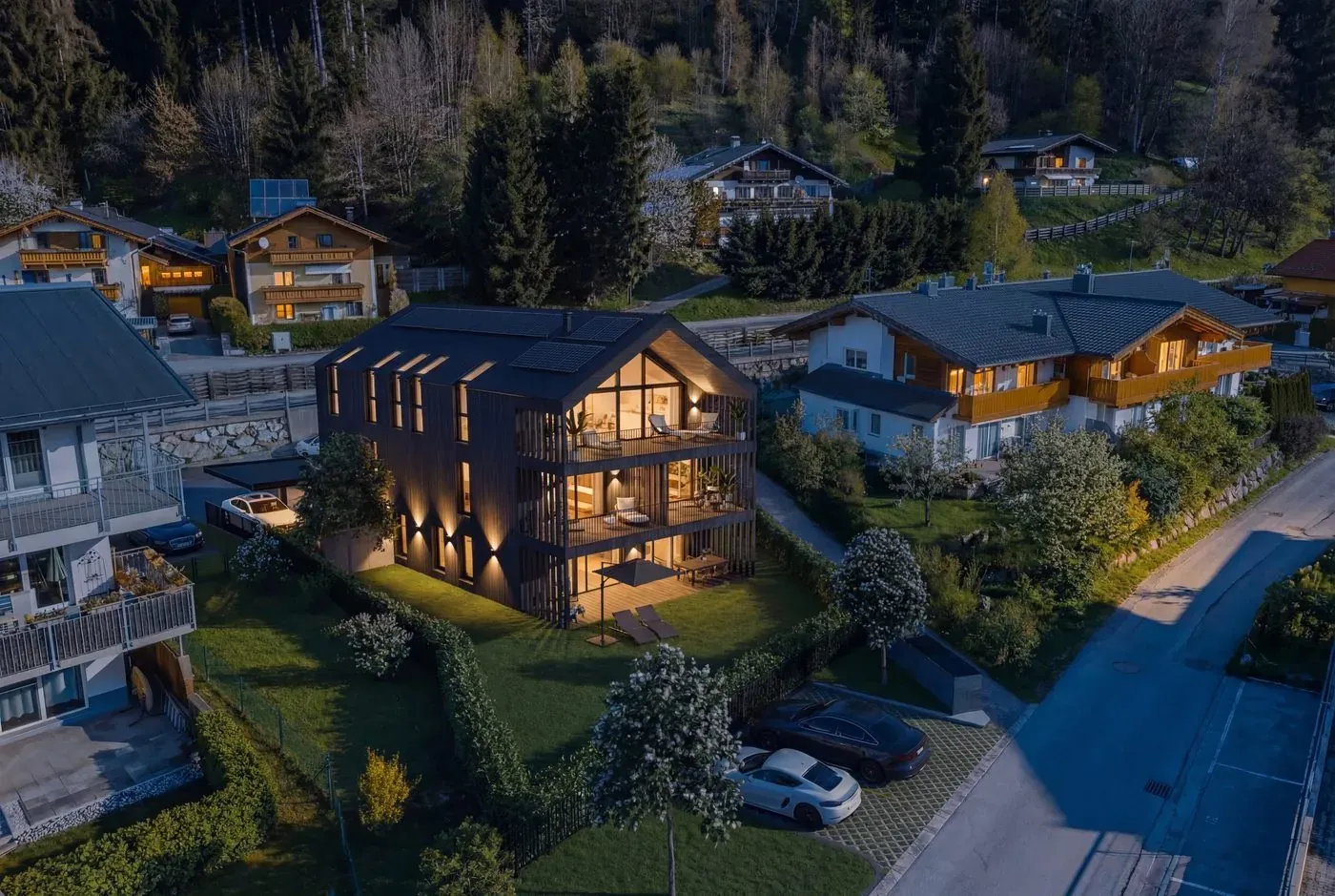 Das Haus bei Nacht mit warm beleuchteten Fenstern