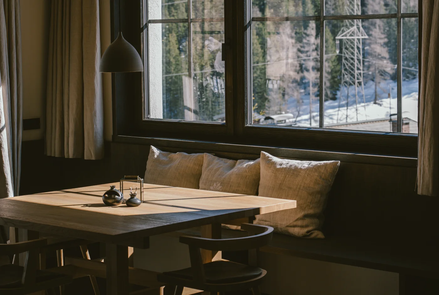 Essbereich mit Sitzbank und Fensterblick in die verschneite Winterlandschaft