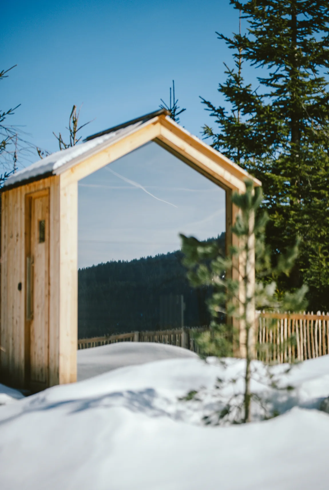 Private Außensauna mit Panoramafenster und Blick in den verschneiten Bergwald